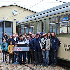 Vereinsmitglieder des Historischer Stadtverkehr Bamberg e. V. vor einer historischen Straßenbahn im Straßenbahndepot St. Peter in Nürnberg